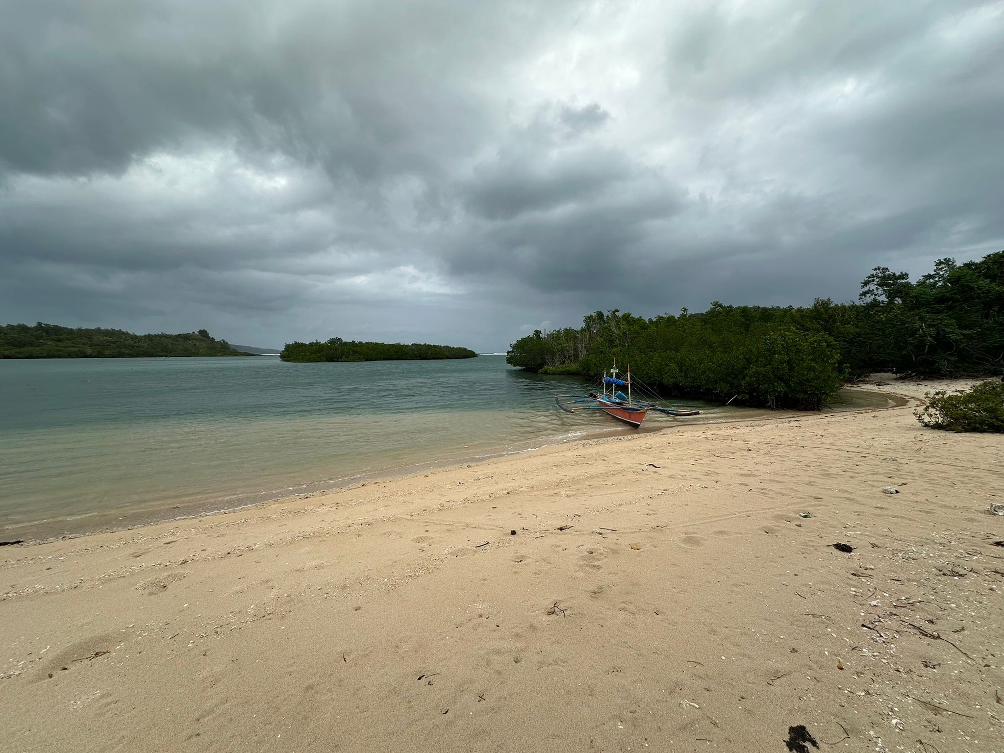 Quiet beach and local boat at Crays Mercedes Island